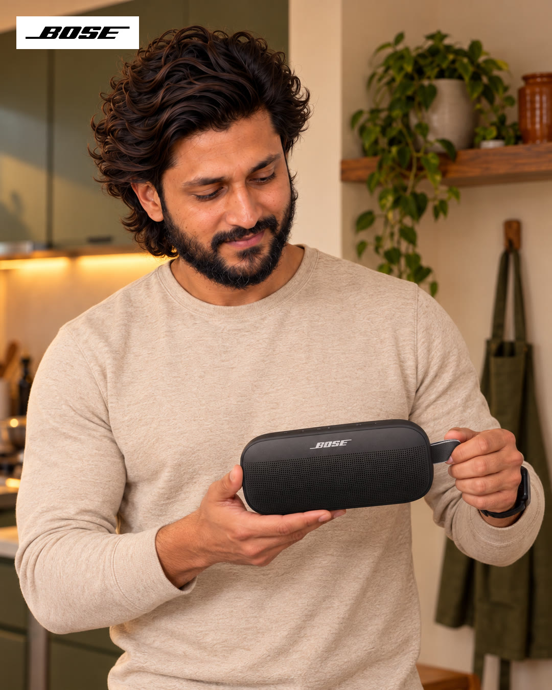 Close-up of the man smiling as he holds a Bose portable speaker in both hands.
