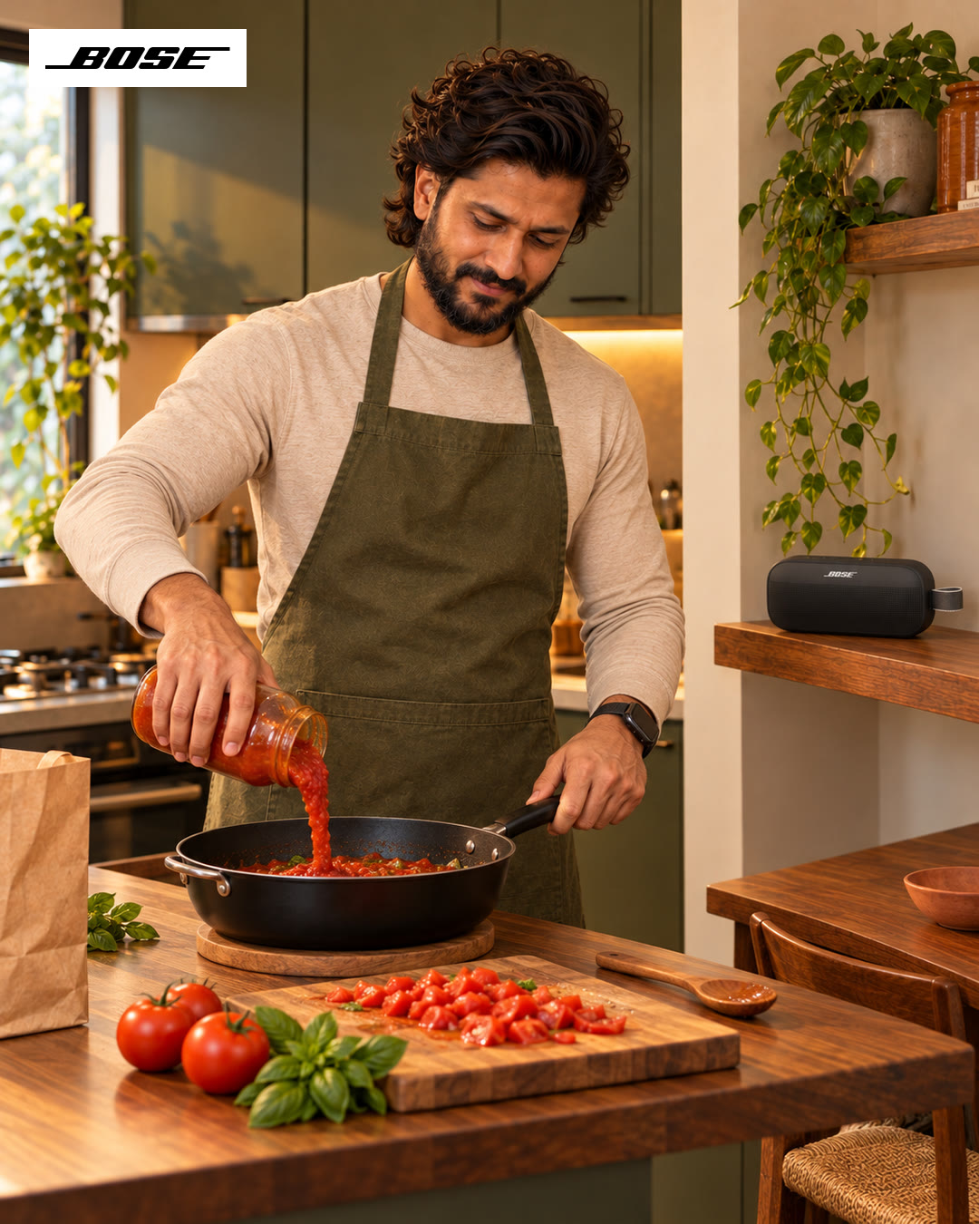 Man in an olive apron pouring tomato sauce into a pan.