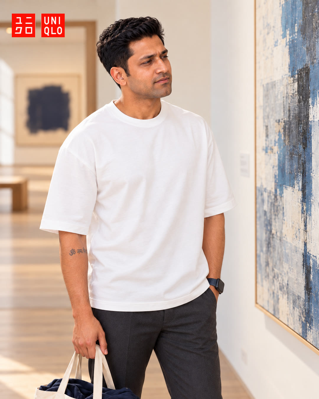 Man in a white t-shirt looking at a large blue abstract painting in a gallery.